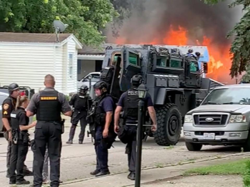 A mobile home caught fire and a police officer was shot inside the residence (Screenshot / Dayton Daily News)