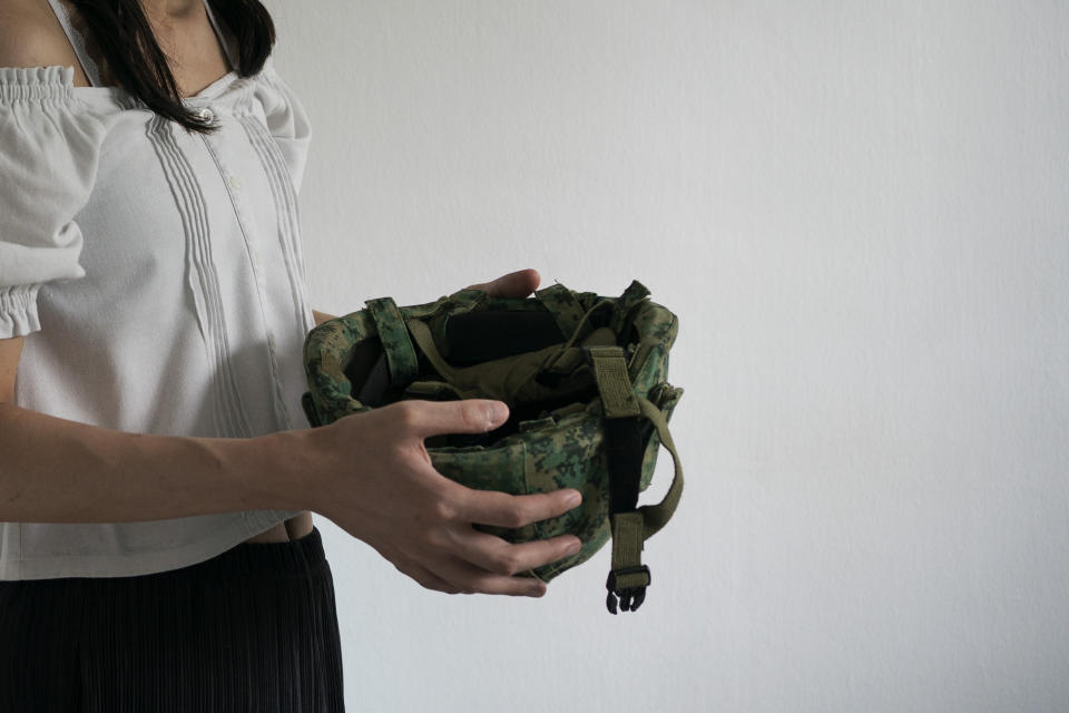 Lune Loh, 25, a transgender woman, holds a helmet that was issued to her when she served in the military in Singapore, in this Thursday, Aug. 18, 2022, photo. Singapore's compulsory, two-year military service is required only for 18-year-old men. But under Singapore law, Loh was still considered a man, because she had not undergone surgery that would render her sterile. (AP Photo/Wong Maye-E)