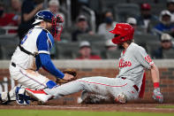 Philadelphia Phillies' Alec Bohm (28) beats the tag from Atlanta Braves catcher Travis d'Arnaud (16) to score the winning run on a Didi Gregorius sacrifice fly in the ninth inning of a baseball game Sunday, April 11, 2021, in Atlanta. (AP Photo/John Bazemore)