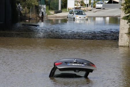 An abandoned car is submerged in deep water near by an underpass after flooding caused by torrential rain in Mandelieu, France, October 4, 2015. REUTERS/Eric Gaillard