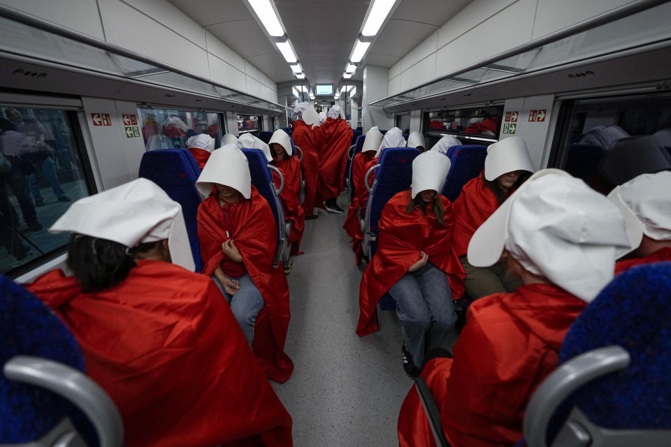 Protesters supporting women's rights dressed as characters from The Handmaid's Tale TV series traveling to a protest against plans by Prime Minister Benjamin Netanyahu's new government to overhaul the judicial system, at a railway station in Jerusalem, Wednesday, March 1, 2023. (AP Photo/Ohad Zwigenberg)