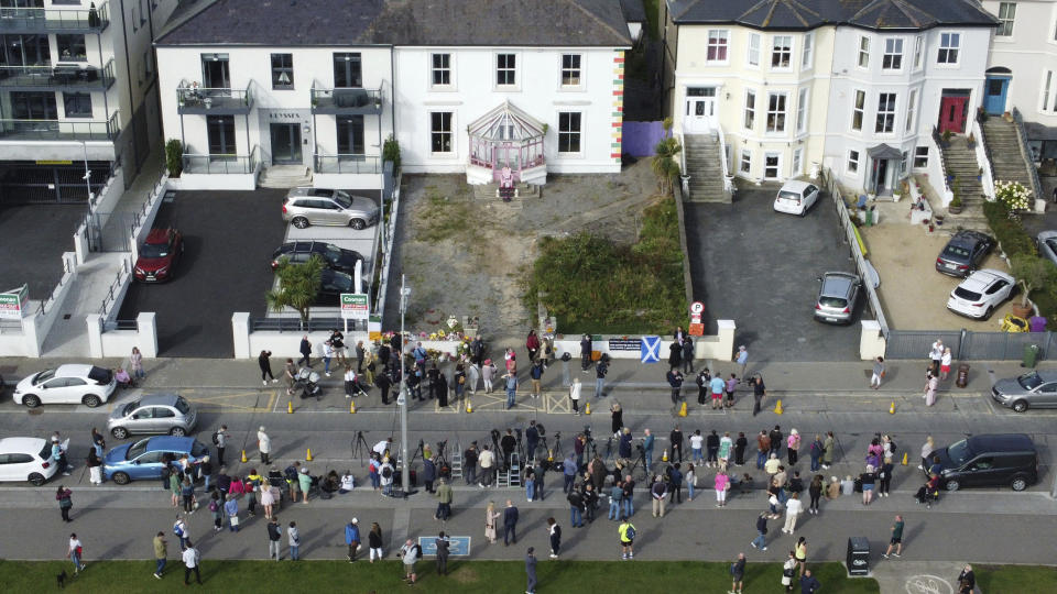 Fans reunidos fuera de la antigua casa de Sinéad O'Connor previo al funeral de la cantante en Bray, en el condado de Wicklow, Irlanda, el martes 8 de agosto de 2023. (Niall Carson/PA vía AP)