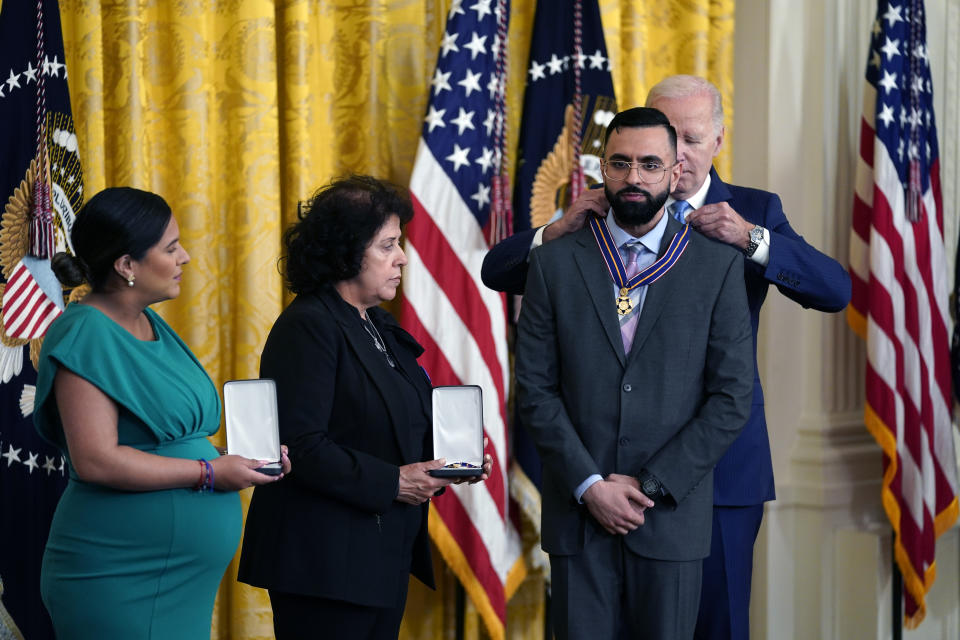 President Joe Biden presents the Medal of Valor, the nation's highest honor for bravery by a public safety officer, to Detective Sumit Sulan of the New York City Police Dept, during an event in the East Room of the White House, Wednesday, May 17, 2023, in Washington, as Gabina Mora (Mother), right, accepting on behalf of Fallen Detective Wilbert Mora of the New York City Police Dept., and Dominique Rivera (Wife), accepting on behalf of Fallen Detective Jason Rivera of the New York City Police Dept., loos on. (AP Photo/Evan Vucci)