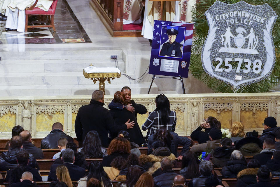 New York City Police Commissioner Keechant L. Sewell, center, hugs officer Jason Rivera's family during his funeral mass, Friday, Jan. 28, 2022, at St. Patrick's Cathedral in New York. (AP Photo/Mary Altaffer, Pool)