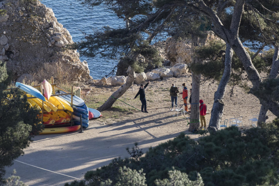 People wearing masks play games at a quarantined vacation center in Carry-le-Rouet, southern France, which is currently accommodating French citizens repatriated from the virus-hit city of Wuhan, Wednesday, Feb. 5, 2020. More than 20,000 people have been infected by the outbreak of a respiratory illness from the coronavirus in China. France has issued an advisory, warning against any non-essential travel to China and suggesting that French citizens who were already there return home. (AP Photo/Daniel Cole)