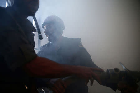 Civil Defence members try to put out a fire inside a building after shelling in the rebel held besieged town of Douma, eastern Ghouta in Damascus, Syria. REUTERS/Bassam Khabieh