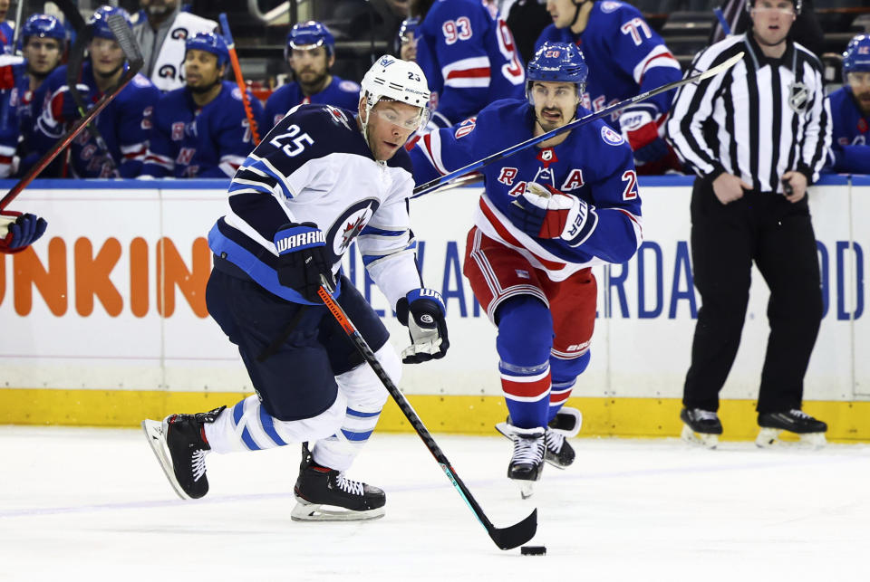 Winnipeg Jets center Paul Stastny (25) skates with the puck against New York Rangers left wing Chris Kreider (20) during the first period of an NHL hockey game Tuesday, April 19, 2022, in New York. (AP Photo/Jessie Alcheh)