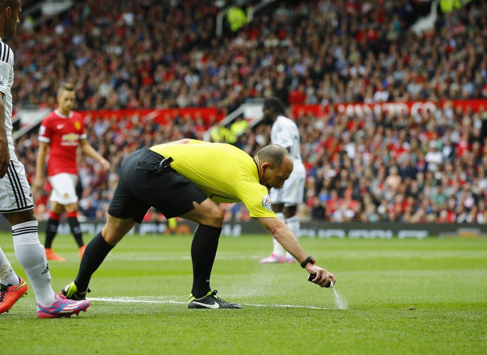 Match referee Dean sprays a free kick line during the English Premier League soccer match between Manchester United and Swansea City at Old Trafford in Manchester