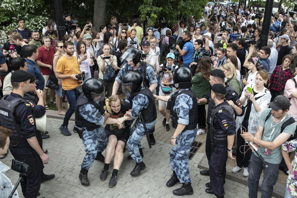 Police officers detain a protester during a march in Moscow, Russia, Wednesday, June 12, 2019. Police and hundreds of demonstrators are facing off in central Moscow at an unauthorized march against police abuse in the wake of the high-profile detention of a Russian journalist. (AP Photo/Pavel Golovkin)