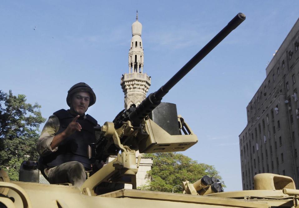 FILE - In this file photo taken Thursday, Nov. 21, 2013, an Egyptian soldier takes position on a military armored vehicle in front of Omar Makram Mosque near Tahrir Square in Cairo, Egypt. The militant group Ansar Beit al-Maqdis, which has waged a campaign of bombings and assassinations for months in Egypt, has quickly advanced in weaponry and sophistication of attacks, drawing on the experience of Egyptians who fought in Syria. (AP Photo/Amr Nabil, File)