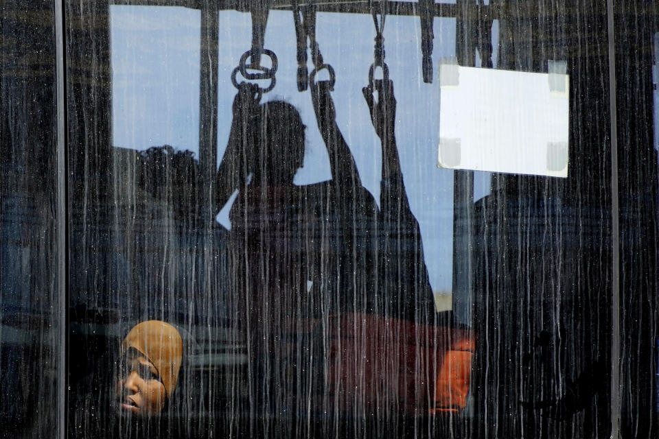 An evacuee from Sudan, sits in a shuttle bus after arriving with a British military transport aircraft at Larnaca airport, Cyprus, Thursday, April 27, 2023. Around 140 people including British and other citizens from European Union countries, arrived in Cyprus after being evacuated from Sudan. (AP Photo/Petros Karadjias)