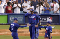 Los Angeles Dodgers' Freddie Freeman, left, and Max Muncy, right, congratulate each other as relief pitcher David Price, second from left, and catcher Will Smith walk toward them after the Dodgers defeated the San Francisco Giants 4-2 in a baseball game Saturday, July 23, 2022, in Los Angeles. (AP Photo/Mark J. Terrill)