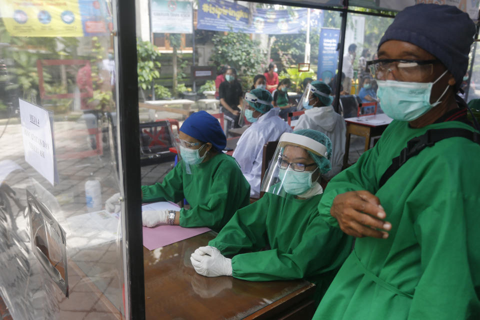 Health workers in a protective suit prepare for a coronavirus vaccine drill in Bali, Indonesia on Monday, Jan. 11, 2021. Indonesia's highest Islamic body has gave its religious approval to China's Sinovac vaccine, paving the way for its distribution in the world's most populous Muslim nation (AP Photo/Firdia Lisnawati)