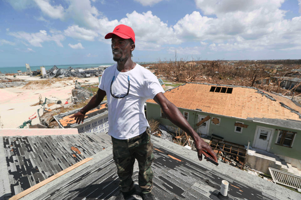 Jackson Blatch starts repairs on the roof of his home in Marsh Harbor, Abaco Island, Bahamas, Saturday, Sept. 7, 2019 after Hurricane Dorian hit. (AP Photo/Fernando Llano)