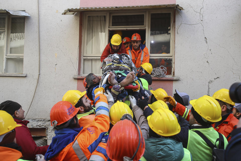 Rescue teams pull out a person from the debris of collapsed buildings in Hatay, southern Turkey, Thursday, Feb. 9, 2023. Emergency crews made a series of dramatic rescues in Turkey on Friday, pulling several people, some almost unscathed, from the rubble, four days after a catastrophic earthquake killed more than 20,000.(AP Photo/Can Ozer)