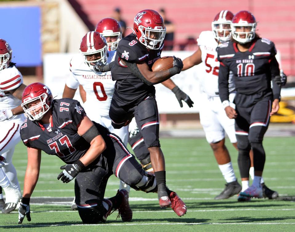 Juwaun Price hurdles over one of his teammates for large gain against the UMass Minutemen in the Aggies final home game on Saturday.