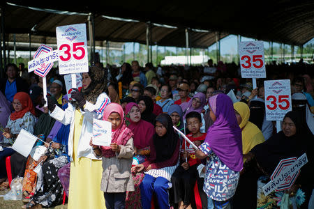 Supporters hold campaign posters at a pro-government Palang Pracharat Party rally in Narathiwat province in Thailand's Deep South region, Thailand, March 17, 2019. REUTERS/Panu Wongcha-um