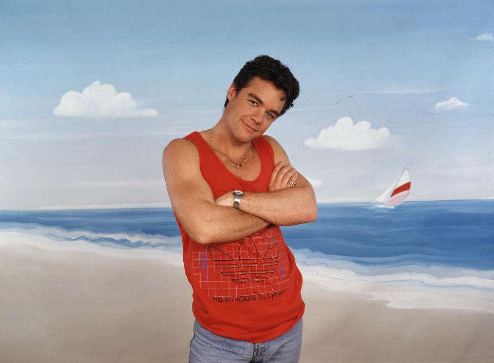 Australian actor Stefan Dennis poses in front of a painted seaside backdrop, circa 1990. Dennis is best known for his role in the Australian soap opera 'Neighbours'. (Photo by Tim Roney/Getty Images)