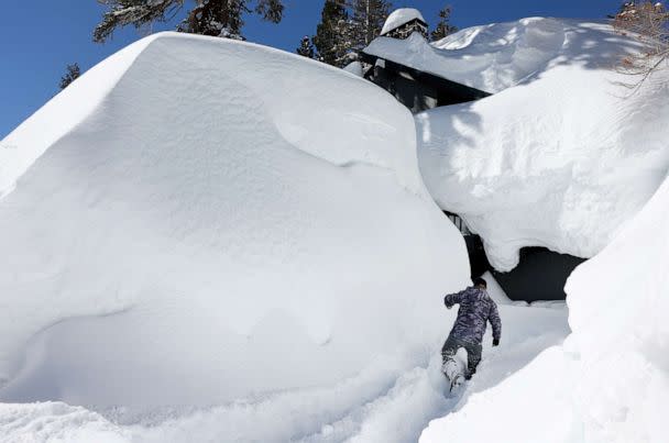 PHOTO: Jeff Wright checks on his neighbor's home in the Sierra Nevada mountains, as snow piled up from new and past storms, March 29, 2023, in Mammoth Lakes, Calif. (Mario Tama/Getty Images)