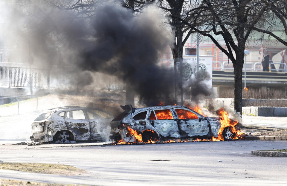 Two cars are burn in a parking lot during a riot in Norrkoping, Sweden, Sunday, April 17, 2022. Unrest has broken out in southern Sweden despite police moving a rally by an anti-Islam far-right group, which was planning to burn a Quran among other things, to a new location as a preventive measure. (Stefan Jerrevang/TT News Agency via AP)