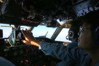 A cabin crew of the Vietnam Air Force is seen onboard a flying AN-26 Soviet made aircraft during a search operation for the missing Malaysia Airlines flight MH370 plane over the southern sea between Vietnam and Malaysia Friday, March 14, 2014. Vietnam says it has downgraded but not stopped its search for the missing jetliner in the South China Sea and has been asked by Malaysian authorities to consider sending planes and ships to the Strait of Malacca. (AP Photo/Na Son Nguyen)