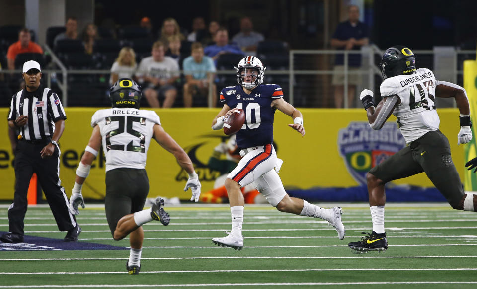 Auburn quarterback Bo Nix (10) looks to pass as Oregon safety Brady Breeze (25) and Oregon defensive end Gus Cumberlander (45) pursue during the first half of an NCAA college football game, Saturday, Aug. 31, 2019, in Arlington, Texas. (AP Photo/Ron Jenkins)