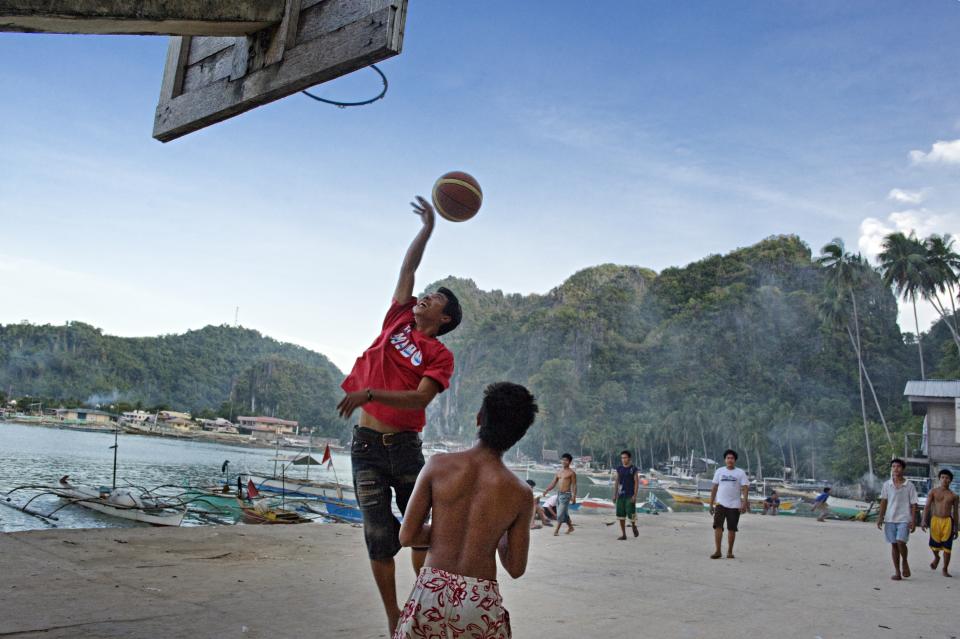 FILE PHOTO: At a fishing village in El Nido, Palawan, the Philippines, young men play basketball at the end of their work day. (Photo by Jonas Gratzer/LightRocket via Getty Images)