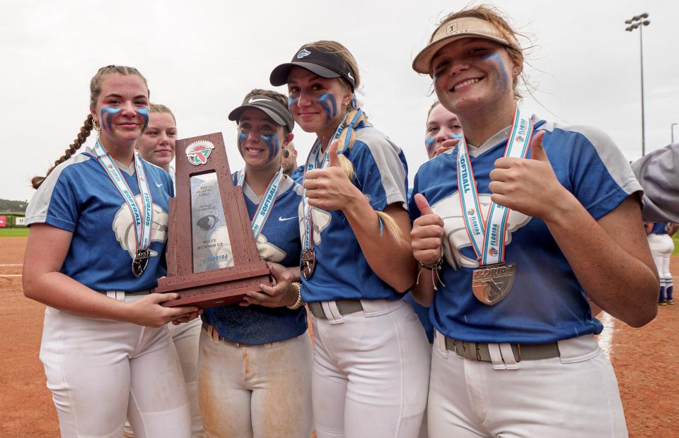 Deltona's seniors (From left, Katie McCaw (8), Morgan Davis, Emily Donohue (1), Veronica Puckett (4), Delanie Perry and Megan Bint (7)) pose with the runner-up trophy after the Class 5A state championship game at Legends Way Ball Fields in Clermont on Thursday.