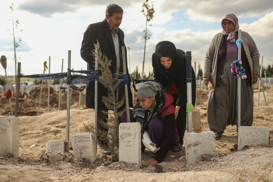 People at the cemetery as they bury their loved ones, victims of Monday earthquake, in Adiyaman, Turkey, Friday, Feb. 10, 2023. Emergency crews made a series of dramatic rescues in Turkey on Friday, pulling several people, some almost unscathed, from the rubble, four days after a catastrophic earthquake killed more than 20,000.(AP Photo/Emrah Gurel)