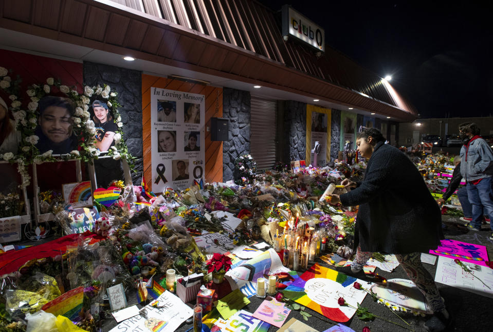 FILE - Kebrina Chirdon lights candles at a memorial outside of Club Q on Friday, Nov. 25, 2022, in Colorado Springs, Colo. A year and a half before the Colorado Springs gay nightclub shooting that left five dead, the alleged shooter was accused of threatening to kill his grandparents if they stood in the way of his plans to become “the next mass killer.” (Parker Seibold/The Gazette via AP, File)