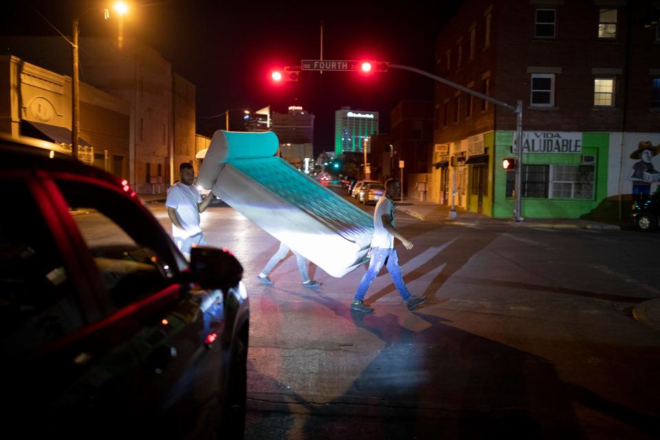 A group of migrants carry an air mattress gifted to them outside Sacred Heart Church in El Paso, Texas, Tuesday, May 9, 2023.