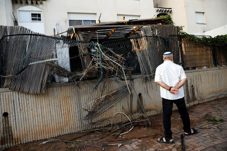 An Israeli man walks near a house where a rocket fell in the Israeli southern city of Sderot, on the Israeli side of the Israel - Gaza border July 14, 2018 REUTERS/Amir Cohen