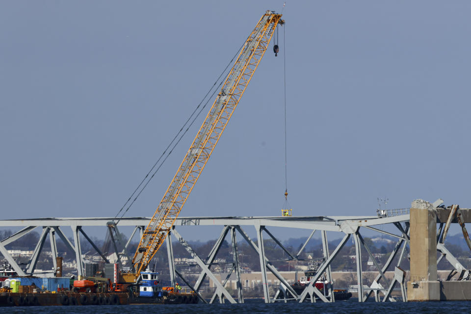 Trabajadores en una grúa trabajan en el puente derrumbado Francis Scott Key de Baltimore, el sábado 30 de marzo de 2024. (AP Foto/Julia Nikhinson)