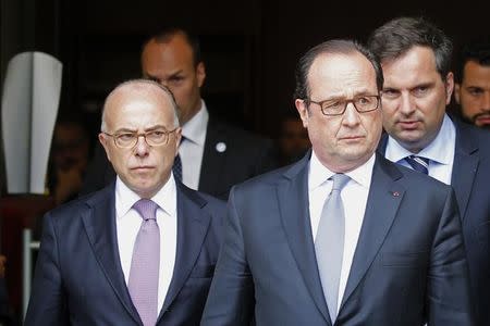 French President Francois Hollande (R) and French Interior Minister Bernard Cazeneuve leave the city hall after a hostage-taking in the church in Saint-Etienne-du-Rouvray near Rouen in Normandy, France, July 26, 2016. REUTERS/Pascal Rossignol