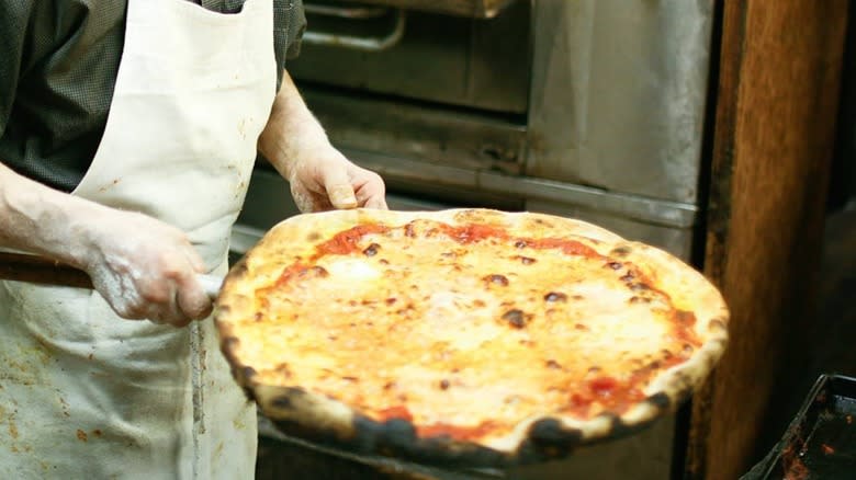 Domenico De Marco holding pizza