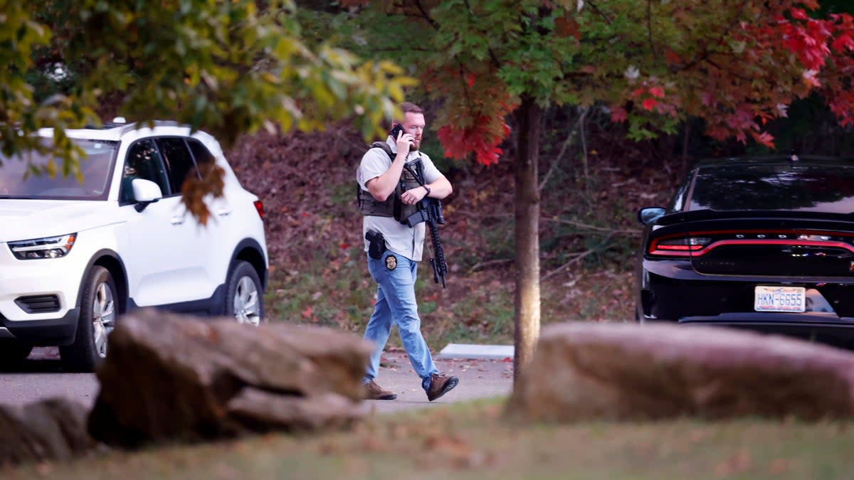 Law enforcement officer walks at the entrance to Neuse River Greenway Trail parking at Abington Lane following a shooting in Raleigh, North Carolina  (AP)