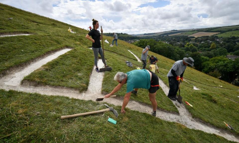 Volunteers rechalking the Cerne Giant’s ribs