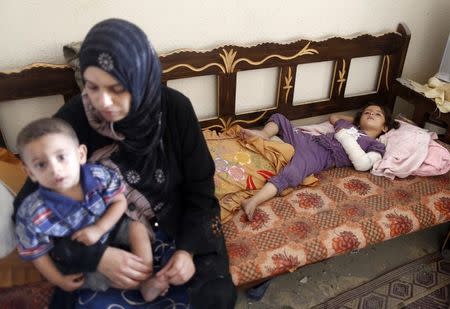 A Palestinian girl, whom medics said was wounded in an Israeli air strike on her family's house, lies inside the damaged house in Gaza City August 2, 2014. REUTERS/Suhaib Salem