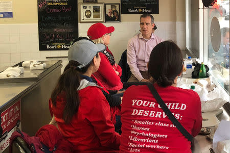 Los Angeles Mayor Eric Garcetti sits at a deli counter and talks with striking teachers in downtown Los Angeles, California, U.S., January 15, 2019. REUTERS/Alex Dobuzinskis