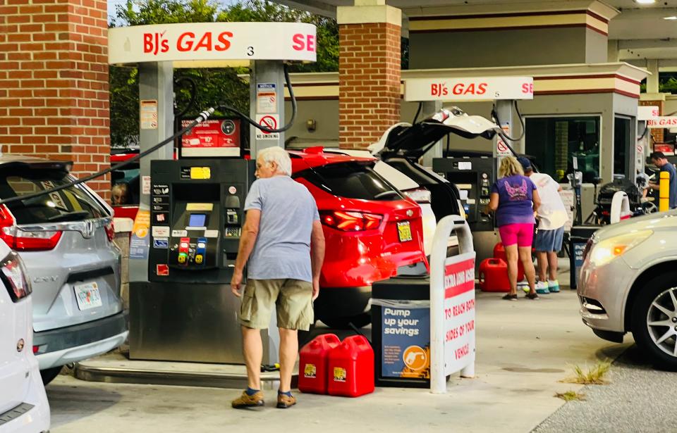 Motorists fill up not just the gas tanks of their cars, but also extra gas cans at the members-only BJ's Wholesale Club gas station in Port Orange on Saturday, Sept. 24, 2022, amid growing concerns that Hurricane Ian could hit the area.