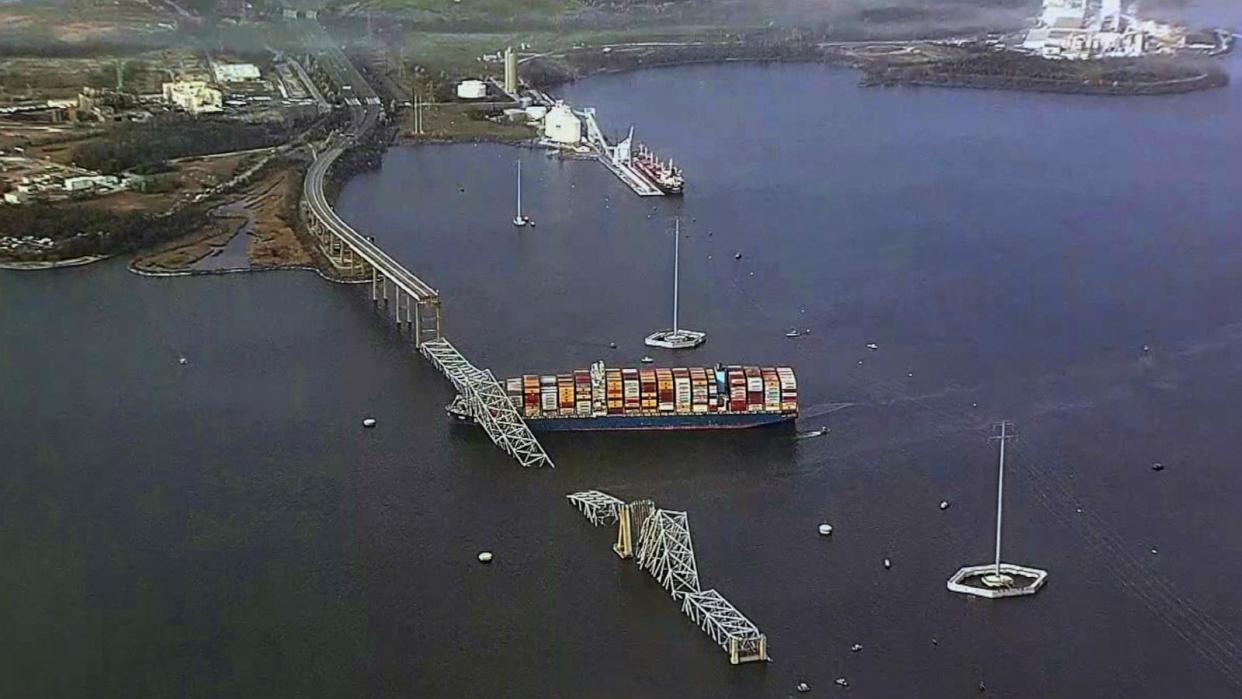 PHOTO: The steel frame of the Francis Scott Key Bridge sits on top of a container ship after it struck the bridge in Baltimore, Mar. 26, 2024. (WJLA)