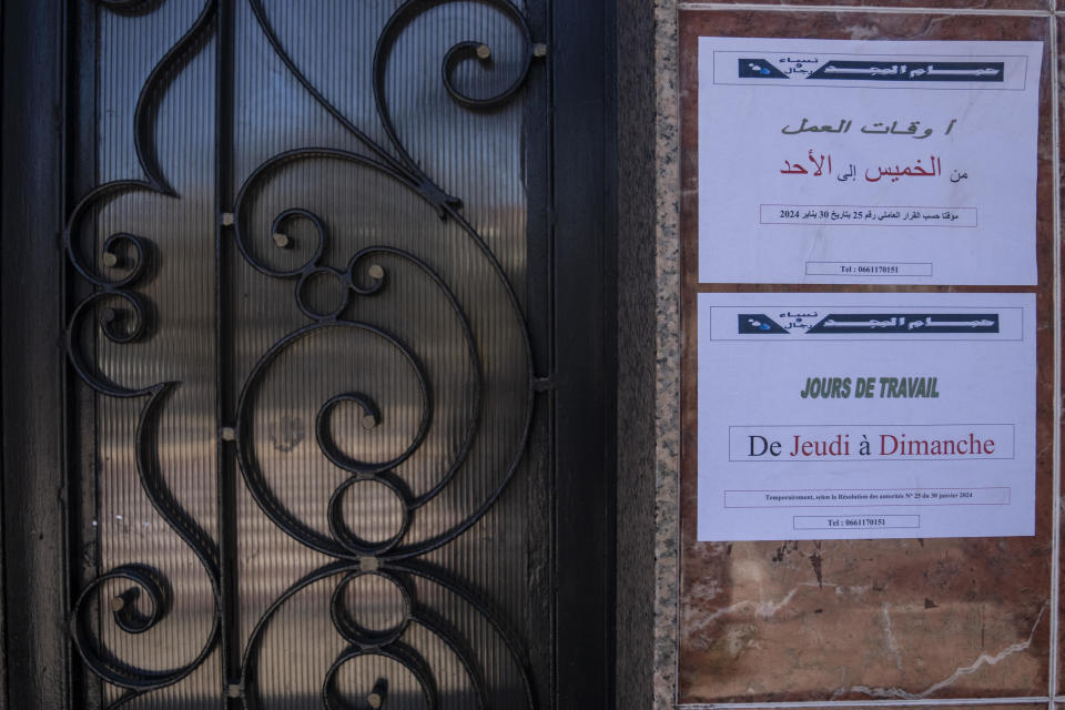 Notice posters are shown outside at a Moroccan traditional bath, known as hammam, while it is empty of customers, in Rabat, Morocco, Monday, March 4, 2024. Climate change and a yearslong drought have forced Morocco's famous public baths to close a few days a week in an effort to save water. The posters in Arabic read, "Open from Thursday to Sunday, as per authorities decision." (AP Photo/Mosa'ab Elshamy)