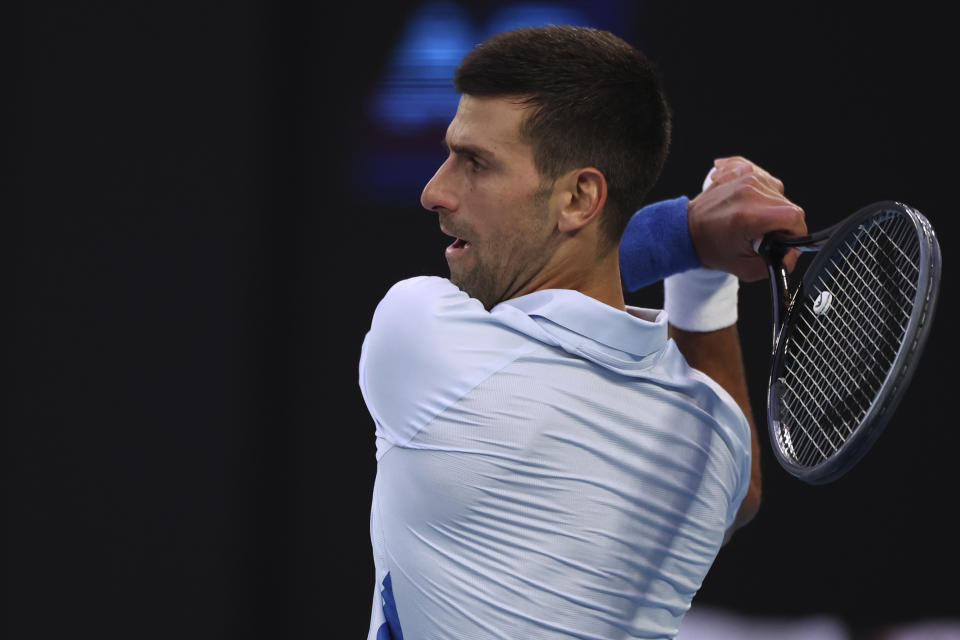 Novak Djokovic of Serbia plays a backhand return to Tomas Martin Etcheverry of Argentina during their third round match at the Australian Open tennis championships at Melbourne Park, Melbourne, Australia, Friday, Jan. 19, 2024. (AP Photo/Asanka Brendon Ratnayake)