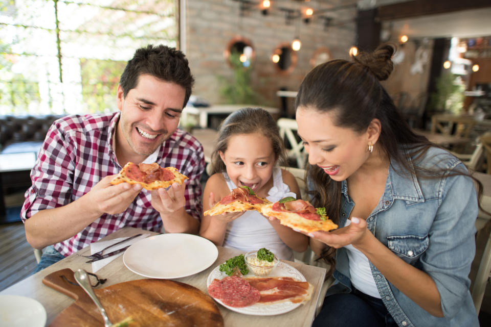 Happy family eating pizza at an Italian restaurant