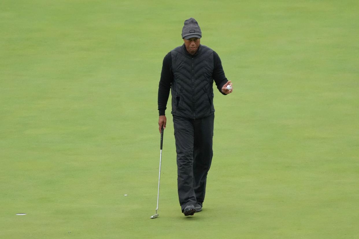 Tiger Woods acknowledges patrons after a putt on the eleventh green during the third round.