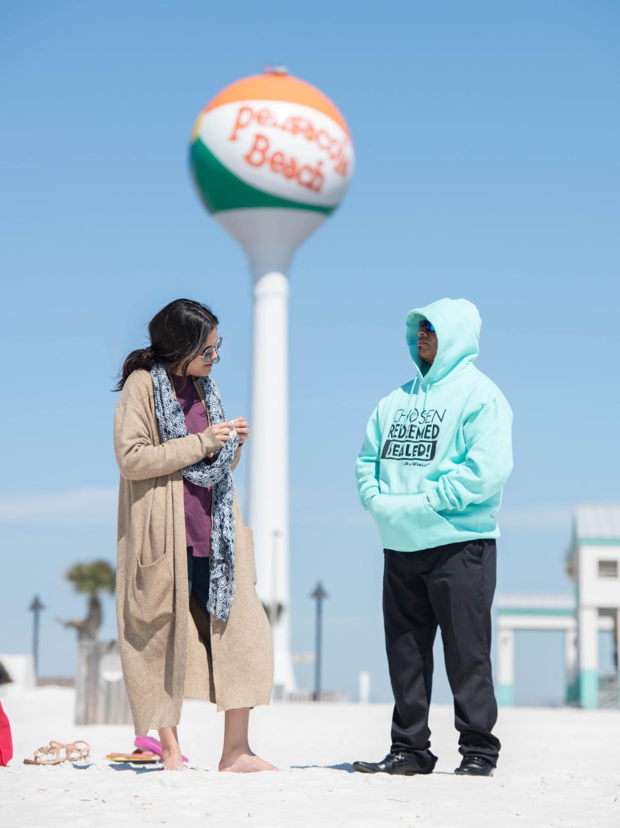 Deiryana DeSousa, left, of Waterloo, Iowa, and Juan Bautista, of Pensacola, spend time on the cold day at Pensacola Beach on Monday, March 20, 2023.