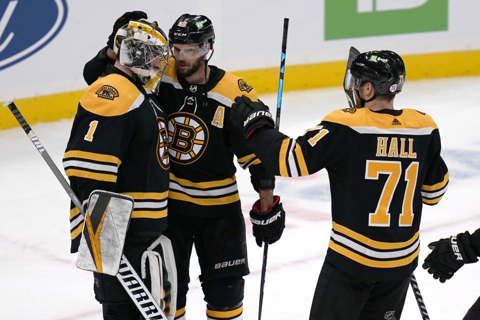 Boston Bruins goaltender Jeremy Swayman (1) is congratulated by David Krejci, center, and Taylor Hall (71) after the team's 3-2 win over Buffalo Sabres in a shootout in an NHL hockey game Tuesday, April 13, 2021, in Boston. (AP Photo/Charles Krupa)