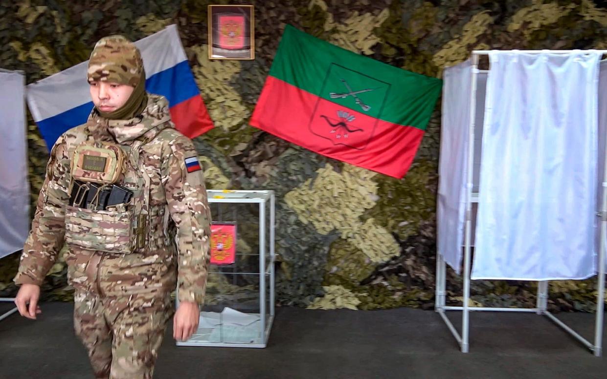 A Russian serviceman walks away after marking his ballot paper