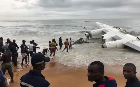 People pull the wreckage of a propeller-engine cargo plane after it crashed in the sea near the international airport in Ivory Coast's main city, Abidjan - Credit: REUTERS