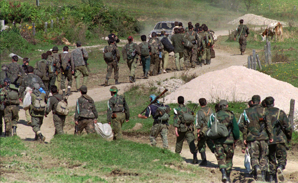 FILE - In this Sept. 28, 1995. file photo, a line of Bosnian government troops makes its way to the front-line near Mrkonjic Grad 120kms (80mls) north west of Sarajevo, Bosnia. While it brought an end to the fighting, the Dayton peace agreement baked in the ethnic divisions, establishing a complicated and fragmented state structure with two semi-autonomous entities, Serb-run Republika Srpska and a Federation shared by Bosniak and Croats, linked by weak joint institutions. (AP Photo/Darko Bandic, File)